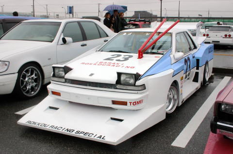 White race car with blue accents, number 23, and a large front splitter labeled 'ROKKOU RACING SPECIAL'