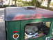 1973 Jeep CJ5 - A green Jeep CJ-5 hardtop shows peeling red paint on its roof and a vent. Gear is visible inside a storage compartment.