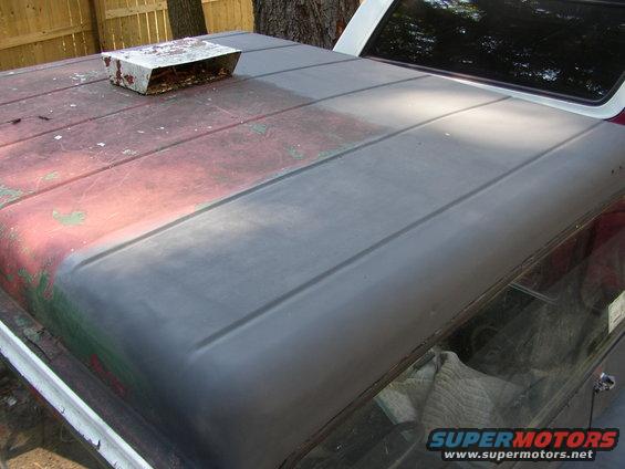 1973 Jeep CJ5 roof with a metal scoop, showing faded red paint and primer