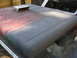 1973 Jeep CJ5 - The roof of a 1973 Jeep CJ5 shows a transition from faded red paint to primer, with a metal scoop attached.