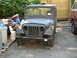 1973 Jeep CJ5 - A vintage Jeep truck with a utilitarian body style is shown in a front view, parked next to another vehicle.