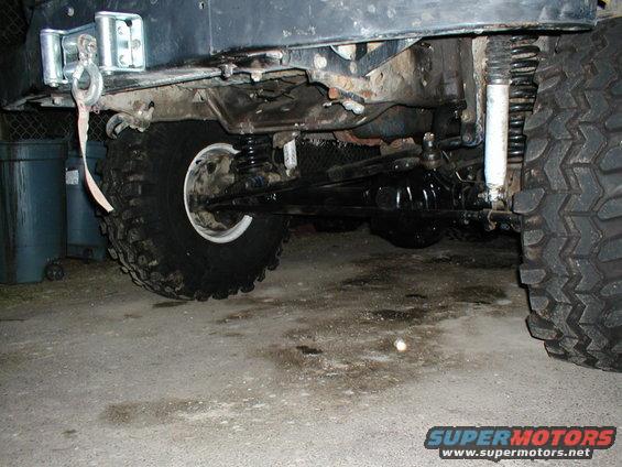 Close-up of the rear axle, suspension, and large tire of an off-road vehicle