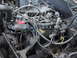 1983 Ford F-250 - Close-up view of a cluttered engine bay with many hoses and wires.