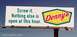 2005 BMW 3 Series - A billboard advertises Denny's with a humorous message about late-night dining options.