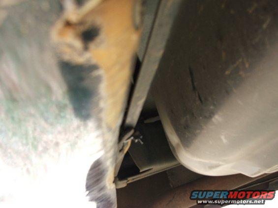 Closeup of the tie wrap to metal crossmember.  Notice all the scuff marks from scraping rear bumper.