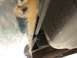 Closeup of the tie wrap to metal crossmember.  Notice all the scuff marks from scraping rear bumper.