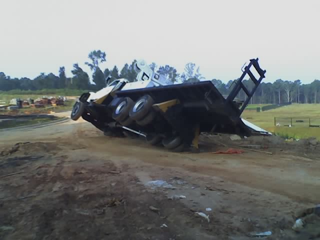 Overturned flatbed truck on a dirt road