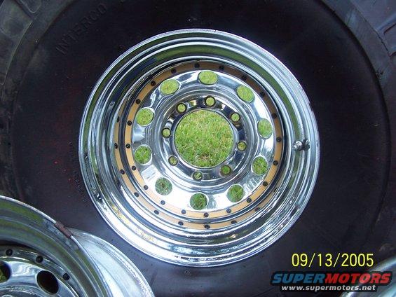 Close-up of a shiny chrome wheel with a large tire. Another wheel is visible in the lower left