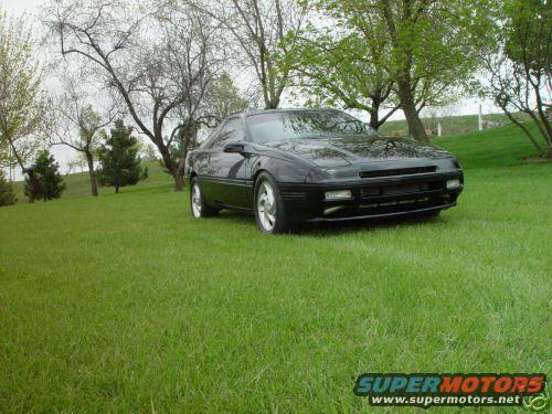 Black sports car parked on a grassy hill