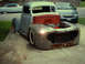 1948 Ford F1 - A custom pickup truck is parked in a driveway, showing its engine and modified front end.