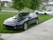 1990 Mitsubishi Eclipse - A black 1990 Mitsubishi Eclipse is parked on a driveway, with two other vehicles visible in the background.