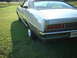 1971 Ford Torino - Rear view of a silver car with a black vinyl roof, parked on a grassy lawn.
