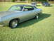 1971 Ford Torino - A silver 1971 Ford Torino coupe with a black vinyl roof is parked on a grassy lawn alongside two other classic cars.
