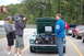 2005 Ford Deluxe - A green 1969 Ford Mustang Mach 1 is filmed with its hood open, parked alongside other vehicles.