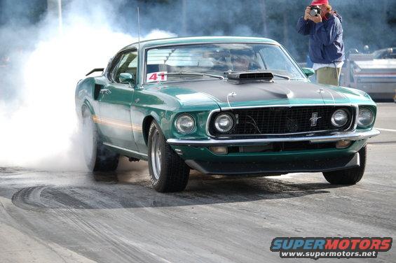 Green 1969 Ford Mustang doing a burnout, front view. Number 41 on windshield