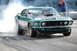 2005 Ford Deluxe - A green 1969 Ford Mustang performs a burnout, emitting a large cloud of smoke. A photographer is visible in the background.
