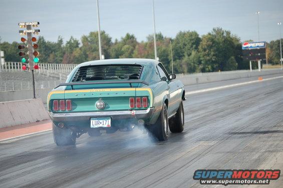 1969 Ford Mustang Mach 1 doing a burnout on a drag strip, rear view. License plate LUR-171