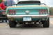 2005 Ford Deluxe - Rear view of a green 1969 Ford Mustang Mach 1 with gold racing stripes and large rear tires.