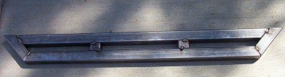 Metal step bars with welded brackets, viewed from above on a concrete surface