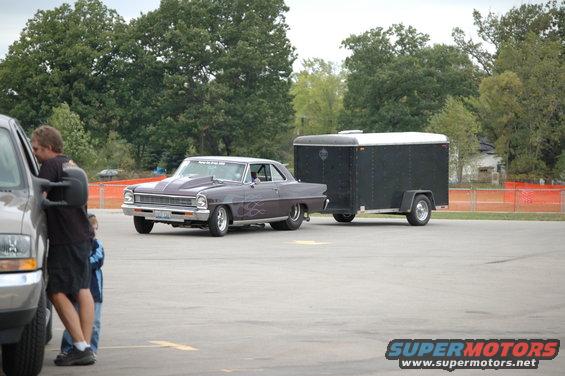 Dark purple 1966 Chevrolet Nova SS with flame decals and a trailer