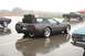 2005 Ford Deluxe - Corvette C4 convertible loaded with luggage on a rainy day, parked alongside other vehicles.