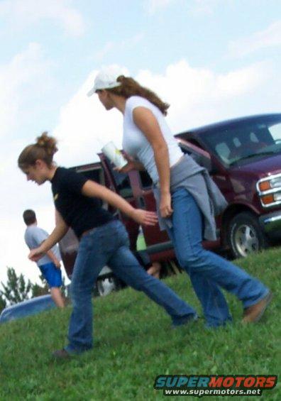 Maroon van side view with two women walking past