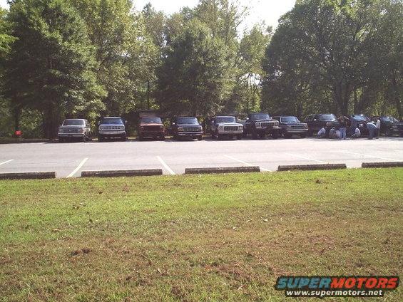 Several Ford Broncos and trucks parked in a lot