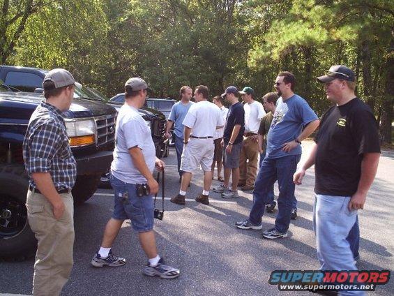Big black truck with a group of guys standing around it