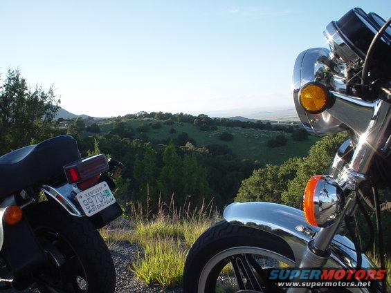 motorcycles parked on a hill overlooking a valley