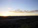 1981 Honda CB750 - A scenic view of a sunset casting a warm glow over rolling hills and a distant road.