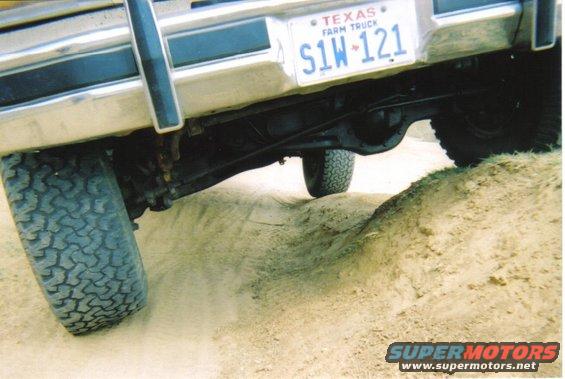 rear of truck going over dirt mound, Texas farm truck license plate visible