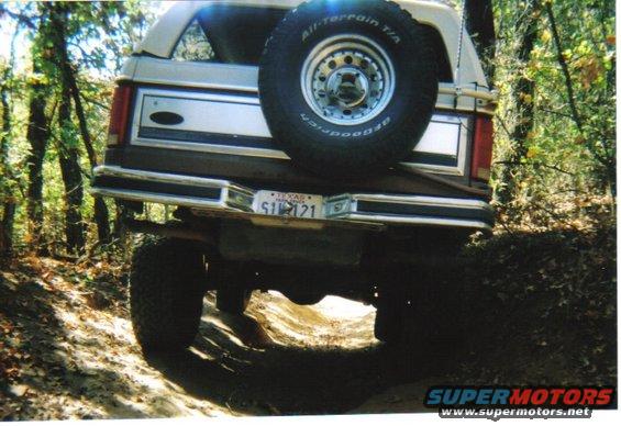Brown Ford Bronco rear view, off-road, with spare tire mounted on back