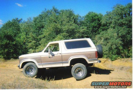 Two-tone brown and white 1982 Ford Bronco parked on dirt road