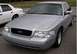 2002 Ford Crown Victoria - Front view of a silver 2002 Ford Crown Victoria, with another similar vehicle partially visible behind it.