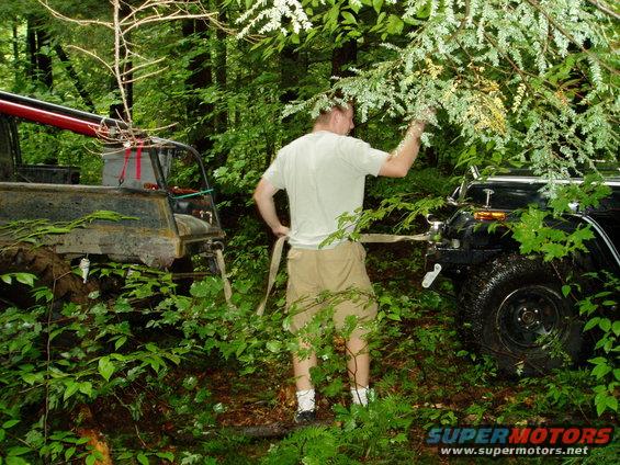 Two off-road vehicles winched in forest