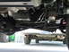 1995 Ford C-350 (Centurion Conversions) - Underside view of a vehicle's drivetrain components, with another car visible below.
