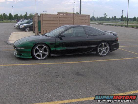 1994 Ford Probe with green flame graphics parked in a lot