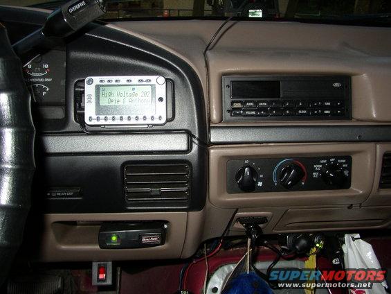 Dashboard of a 1992 Ford Bronco showing radio, climate controls, and aftermarket device