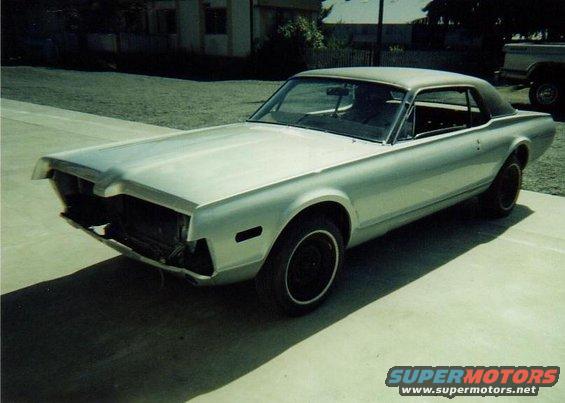 Silver 1967 Mercury Cougar with front end missing, parked outside