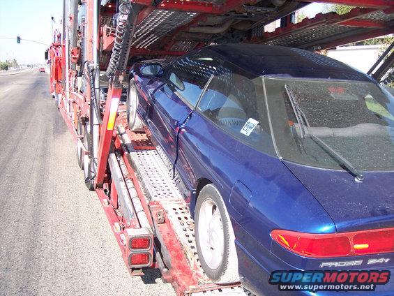 Blue 1995 Ford Probe coupe on a car carrier, rear view