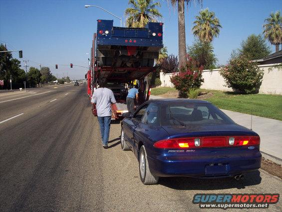 Blue 1995 Ford Probe rear view, being unloaded from a car carrier