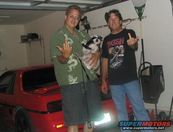 1986 Pontiac Fiero in a garage with two men and a dog
