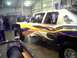 2005 BMW 3 Series - Customized pickup truck with racing stripes and visible roll cage.