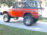 Red 1974 Ford Bronco side view with lifted suspension and aftermarket wheels