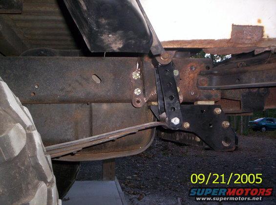 close-up of vehicle's rear suspension with leaf springs and a lift bracket, date stamp 09/21/2005