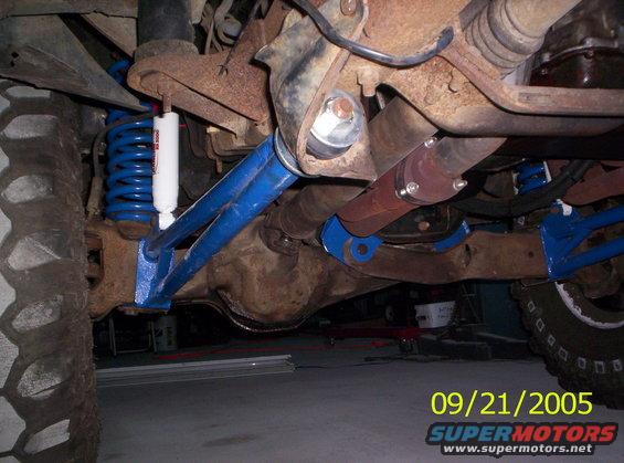 Close-up of blue suspension parts and driveshaft on a vehicle