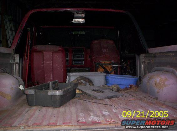 Red Ford Bronco interior and bed with red seats, toolboxes, and storage bins