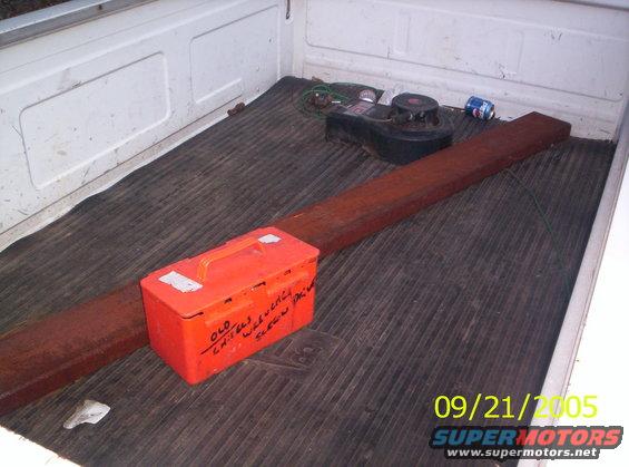 Truck bed with an orange toolbox, lumber, and a small engine part. Date stamp says 09/21/2005
