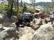 1996 Ford Bronco - Off-road vehicles tackle a challenging rocky path in a wooded, mountainous area.