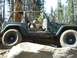 1996 Ford Bronco - A green Jeep Wrangler navigates rocky terrain with a driver behind the wheel.